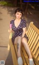 A woman sitting on a bench holding an ice cream cone.