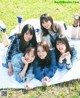 A group of young women laying on top of a blanket.