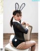 A woman in a bunny costume sitting on a chair.